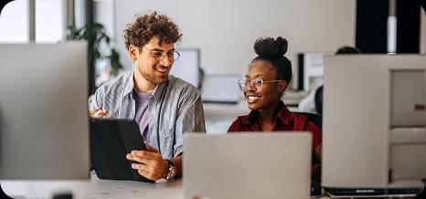two people talking in an office looking at a screen