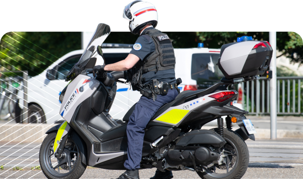 A police officer on a motorcycle in uniform, stationary on a road.